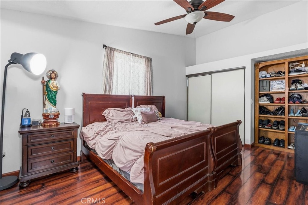 506 South Althea Avenue Rialto, CA 92376 - Photo 11 of 36 a bedroom with a bed and a bookshelf with wooden floor