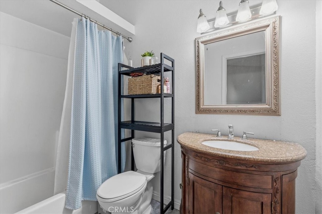 506 South Althea Avenue Rialto, CA 92376 - Photo 12 of 36 a bathroom with a toilet a sink and mirror