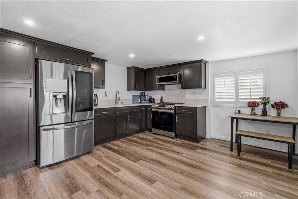 506 South Althea Avenue Rialto, CA 92376 - Photo 8 of 36 a kitchen with kitchen island stainless steel appliances a sink cabinets and a window