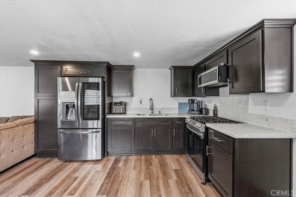 506 South Althea Avenue Rialto, CA 92376 - Photo 9 of 36 a kitchen with granite countertop a refrigerator and a sink