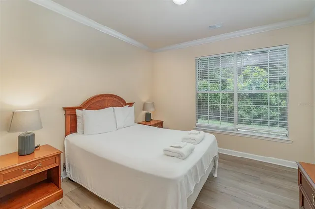 a bedroom with a bed and a lamp next to a window