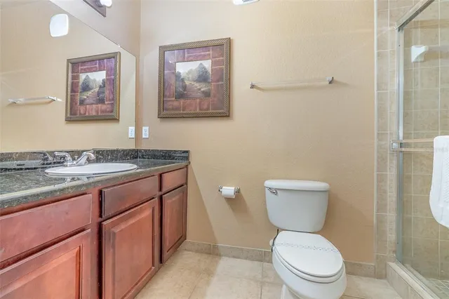 a bathroom with a granite countertop toilet a sink and a mirror