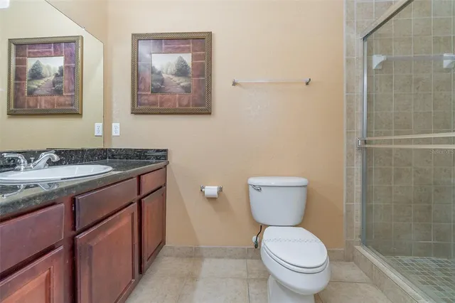 a bathroom with a granite countertop toilet sink and mirror