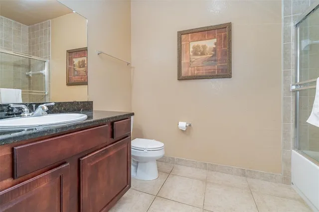a bathroom with a granite countertop sink a toilet and a mirror