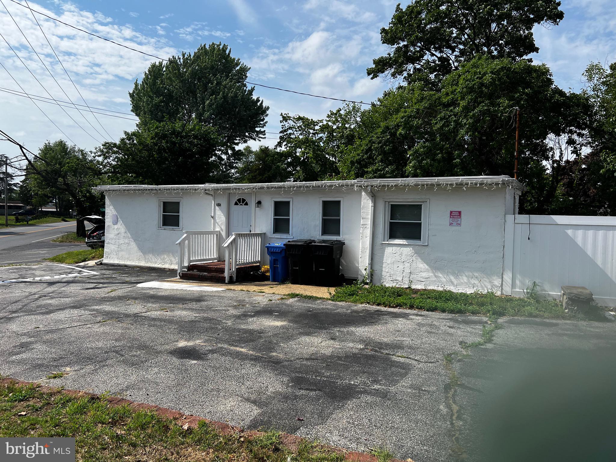 a view of a white house with a yard and large tree