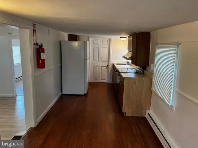 a kitchen with a refrigerator and a stove top oven