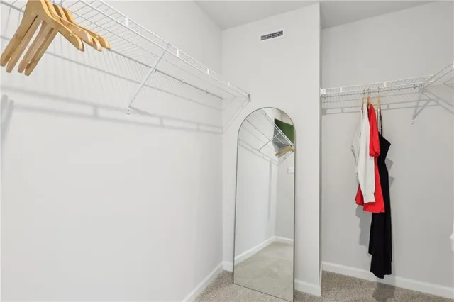 a view of walk in closet with clothes