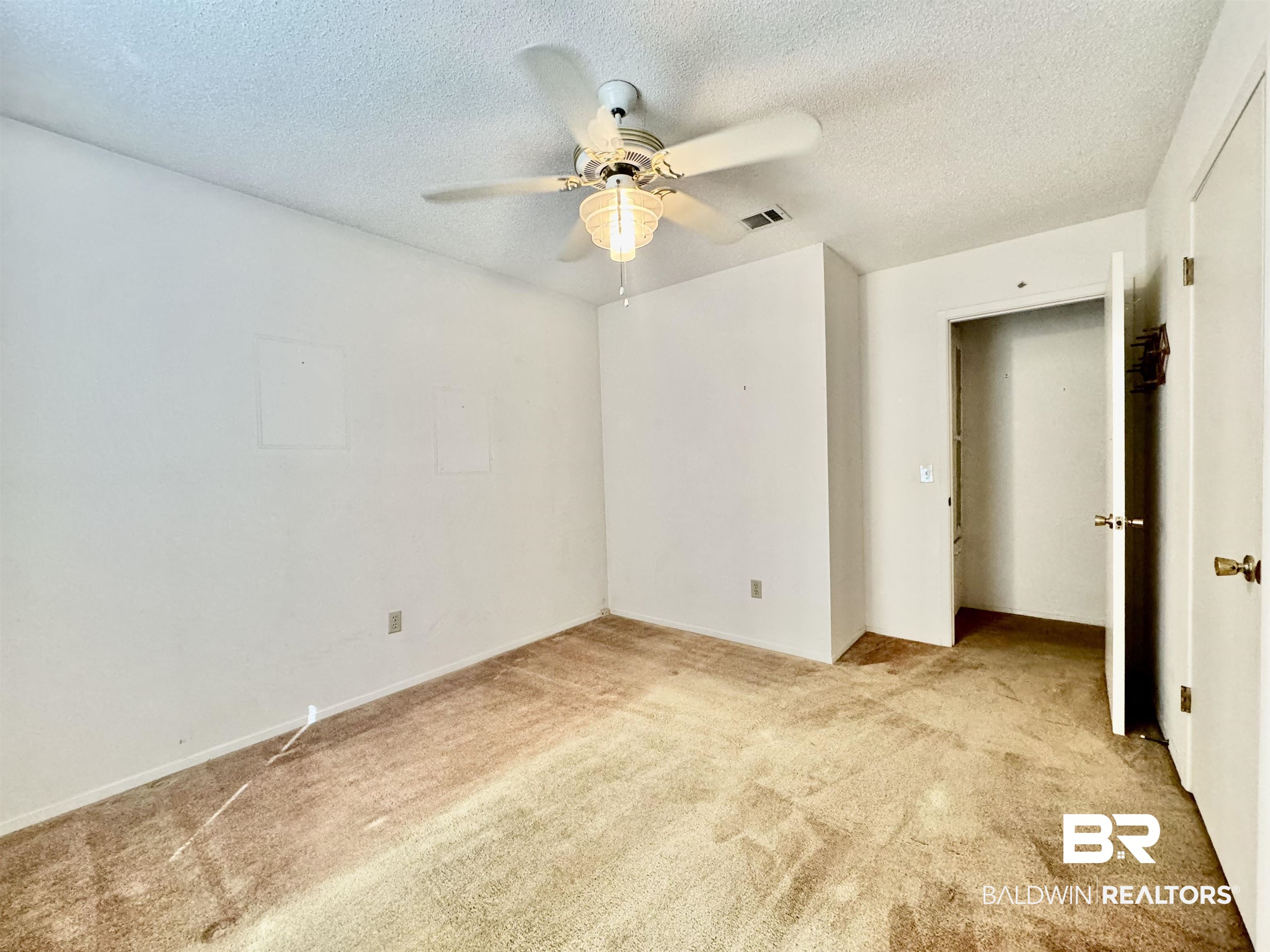 512 Deborah Court Foley, AL 36535 - Photo 16 of 23 Unfurnished bedroom featuring ceiling fan, a textured ceiling, and light carpet