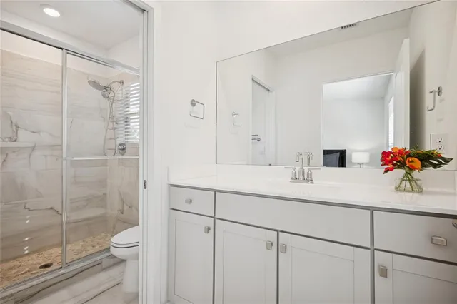 a bathroom with a double vanity sink toilet and shower