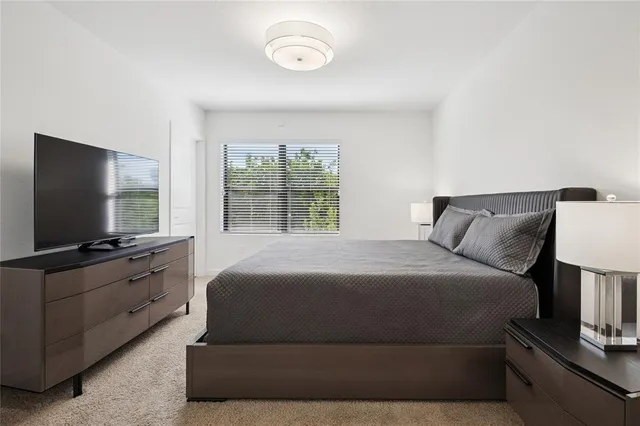 a bedroom with a large bed and a flat screen tv