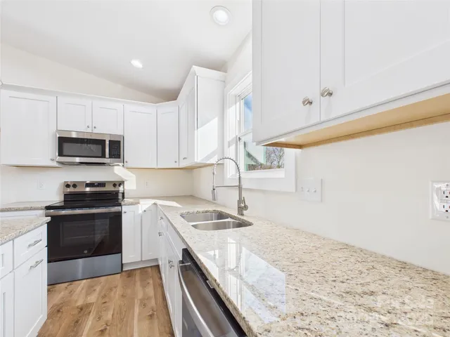 a kitchen with a sink stove top oven and cabinets
