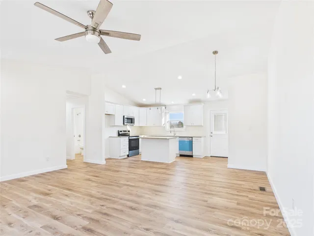 a view of kitchen with kitchen island a sink stainless steel appliances and cabinets