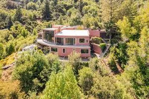 an aerial view of house with yard and mountain view in back