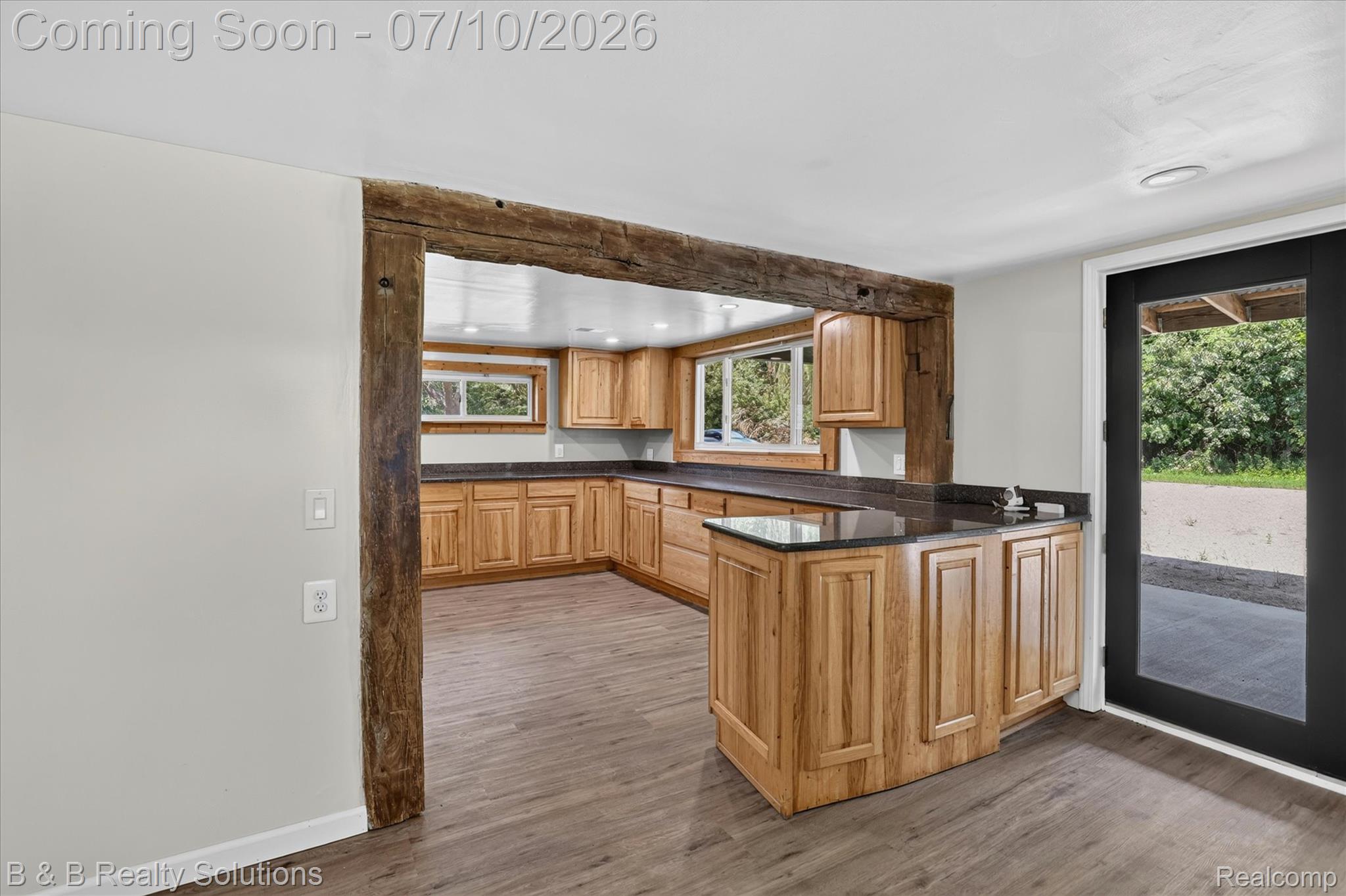 1564 East Burnside Road North Branch, MI 48461 - Photo 2 of 25 Kitchenette featuring a U-shaped layout, natural wood cabinetry, dark countertops, and wood-finish flooring