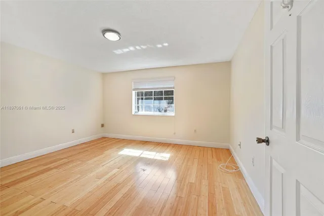 a view of a room with wooden floor and white walls