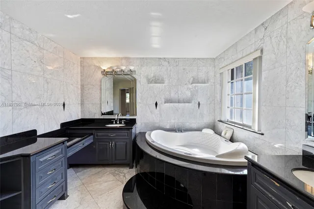 a bathroom with a granite countertop sink a toilet a mirror and shower