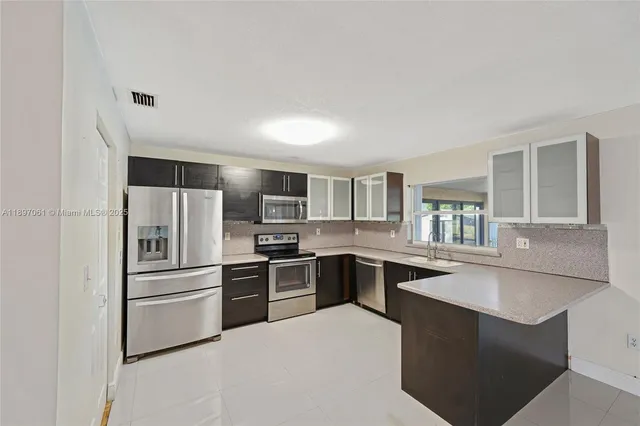 a kitchen with cabinets stainless steel appliances and window