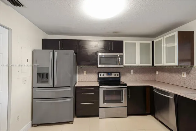 a kitchen with stainless steel appliances and refrigerator