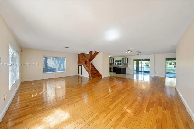 a view of empty room with wooden floor and fireplace