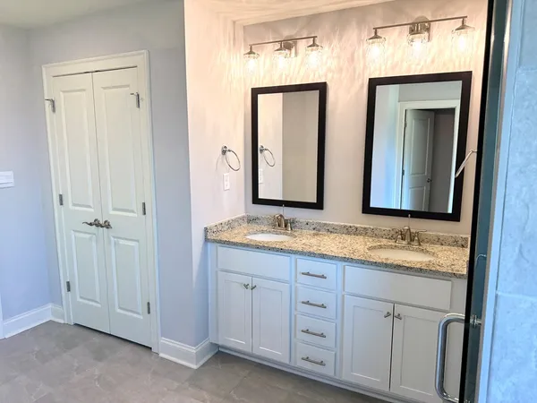 a bathroom with double sink and a mirror