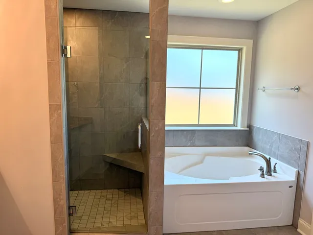 a bathroom with a bathtub and next to a window