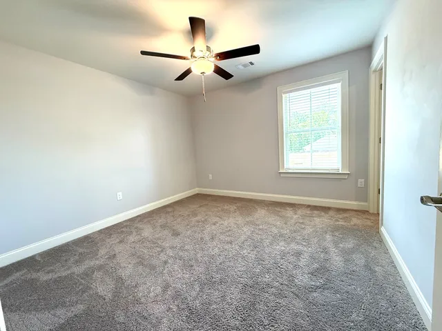 an empty room with a window and a fan