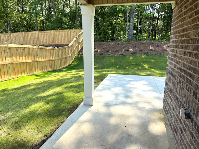 a view of a swimming pool with a yard and large trees