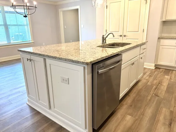 a kitchen with stainless steel appliances granite countertop a sink and dishwasher with wooden floor