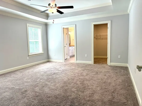 en empty room with windows and ceiling fan