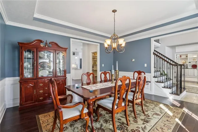 a dining room with furniture a chandelier and wooden floor