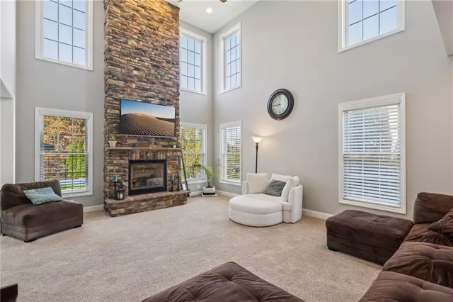 a living room with furniture a fireplace and a large window