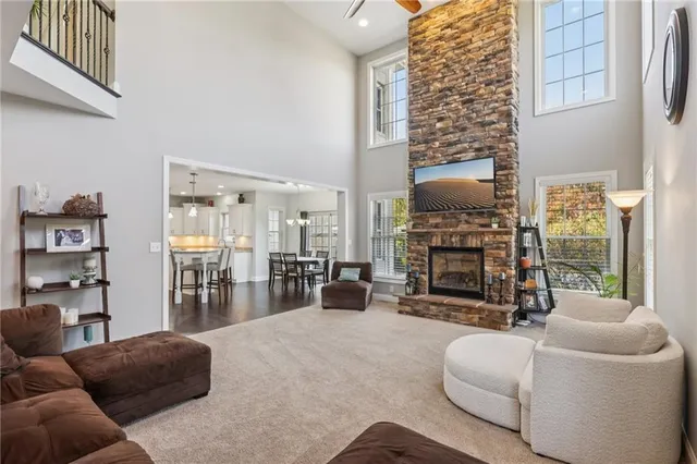 a living room with furniture a fireplace and a large window