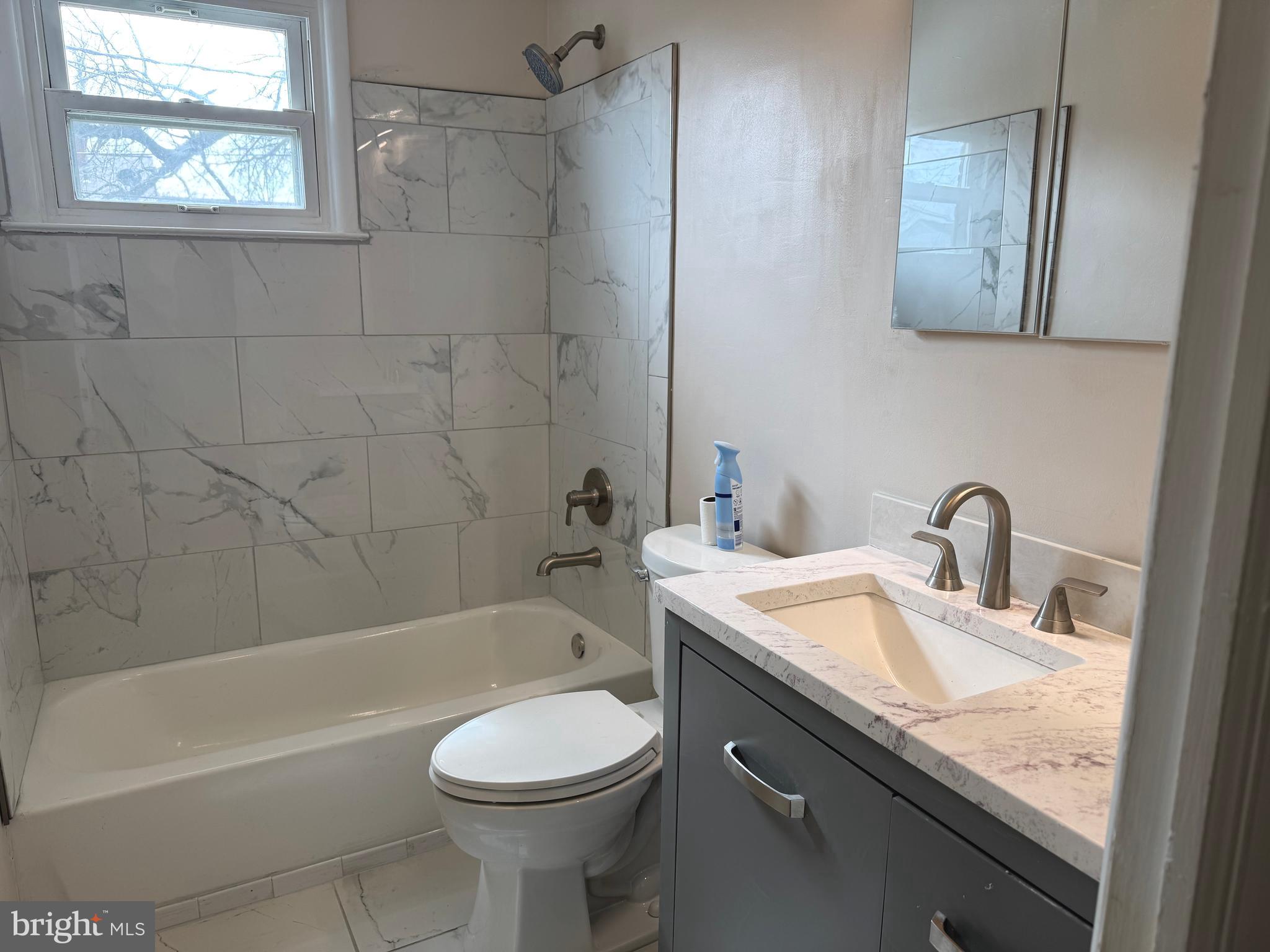 609 Wallerson Road Baltimore, MD 21228 - Photo 5 of 15 a bathroom with a granite countertop sink a toilet and bathtub