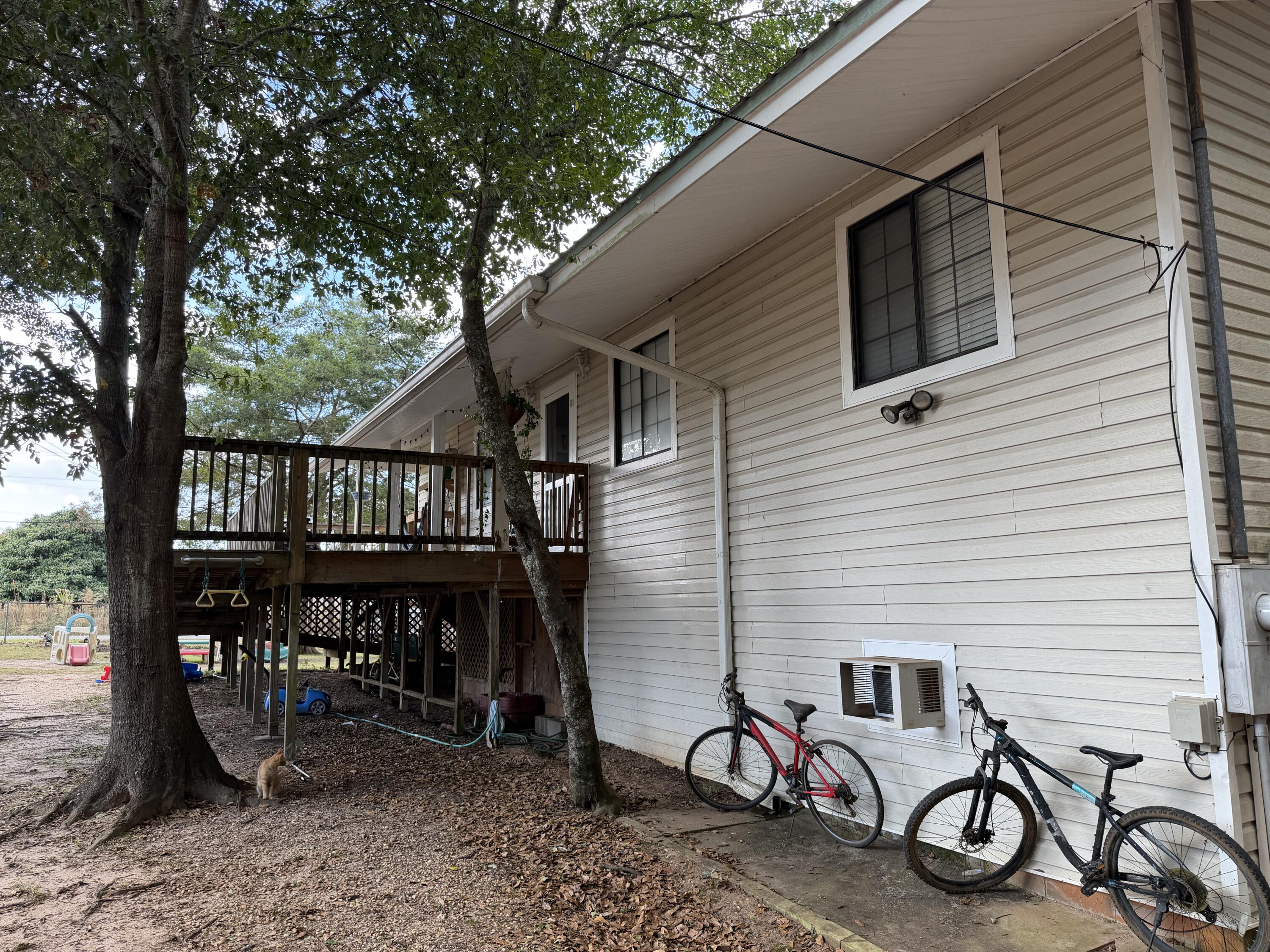 5875 Oak Hill Road Crestview, FL 32536 - Photo 2 of 43 a view of a patio with table and chairs a barbeque with wooden fence and floor