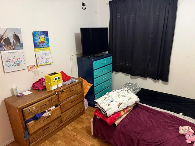 a bed room with a large bed and a flat tv screen