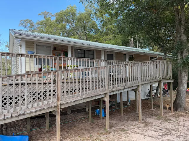 a view of a house with wooden deck and furniture