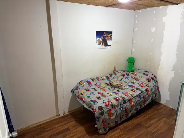 a bedroom with a bed and a wall painting