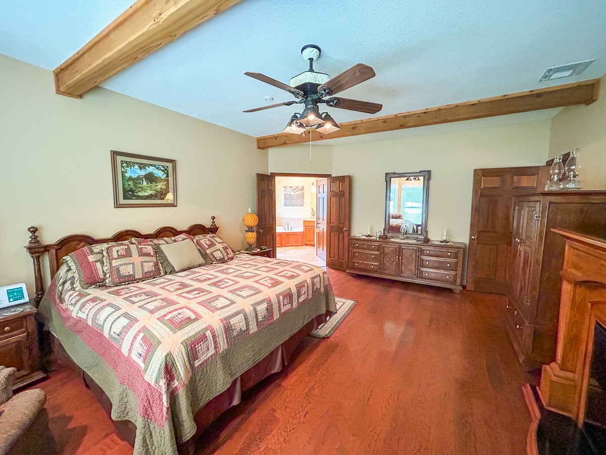 5259 Farm To Market 946 Coldspring, TX 77331 - Photo 15 of 39 a bedroom with a bed and a chandelier