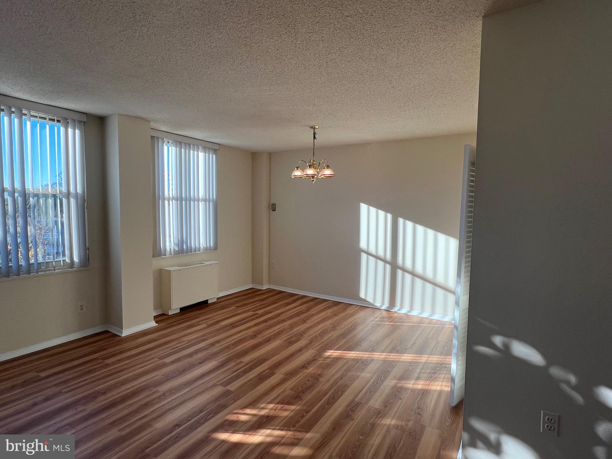 4401 Roland Avenue, Unit 402 Baltimore, MD 21210 - Photo 11 of 43 a view of an empty room with wooden floor and a window