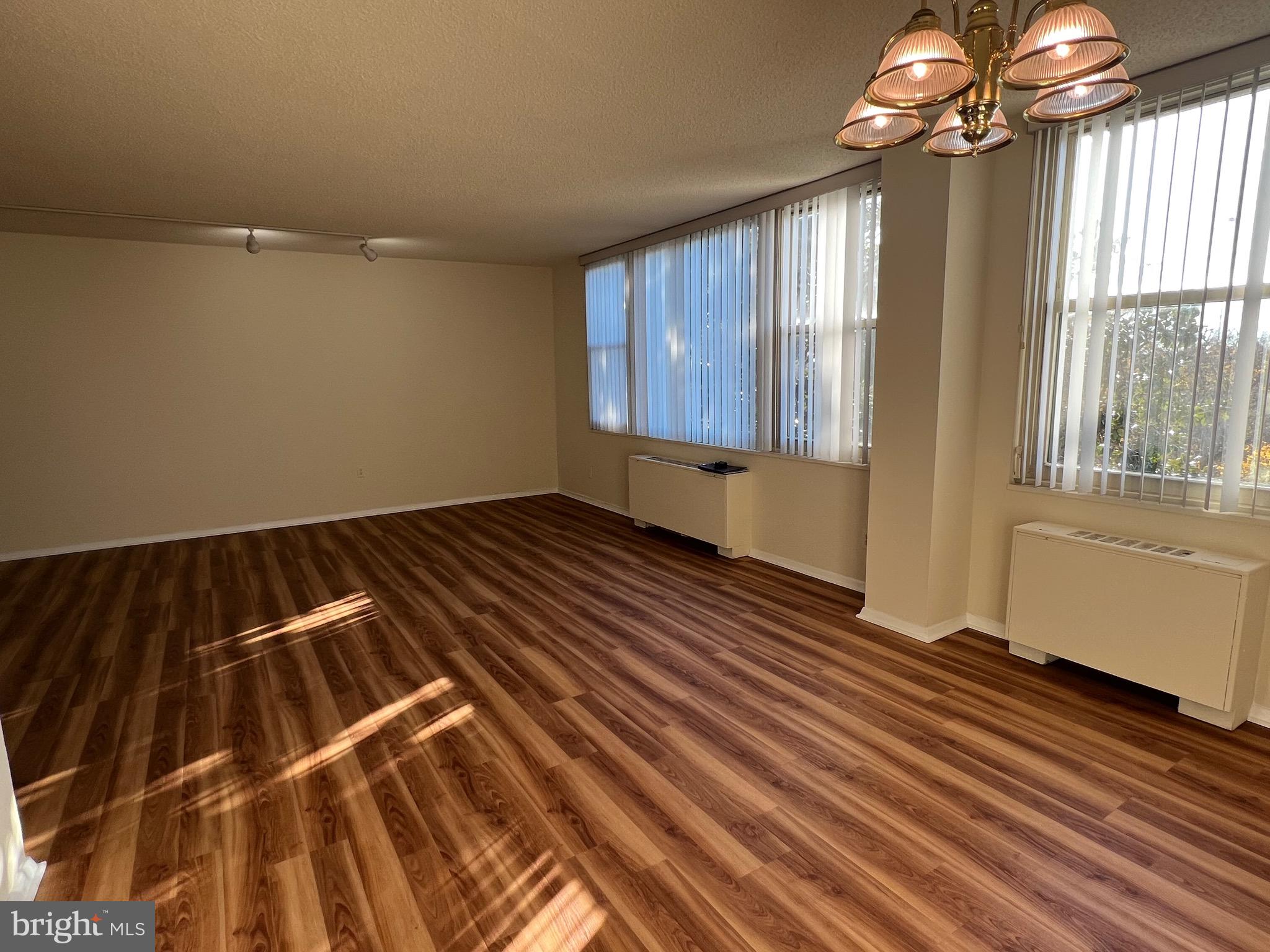 4401 Roland Avenue, Unit 402 Baltimore, MD 21210 - Photo 13 of 43 a view of an empty room with wooden floor and a window