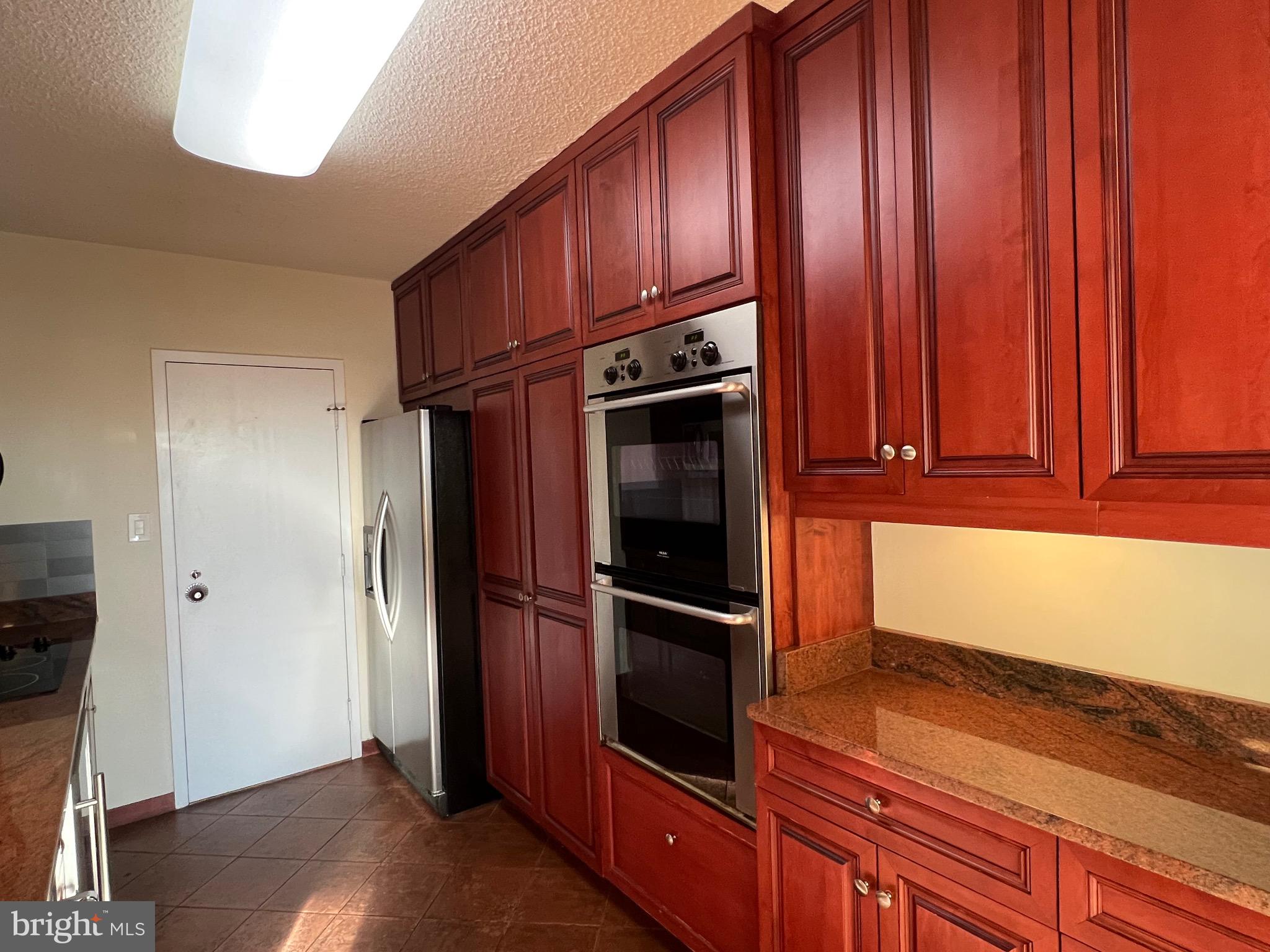 4401 Roland Avenue, Unit 402 Baltimore, MD 21210 - Photo 18 of 43 a kitchen with granite countertop wooden cabinets and stainless steel appliances