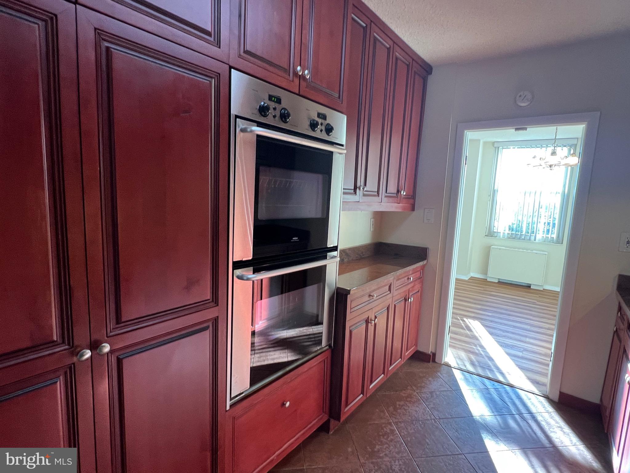 4401 Roland Avenue, Unit 402 Baltimore, MD 21210 - Photo 20 of 43 a kitchen with granite countertop wooden cabinets and stainless steel appliances