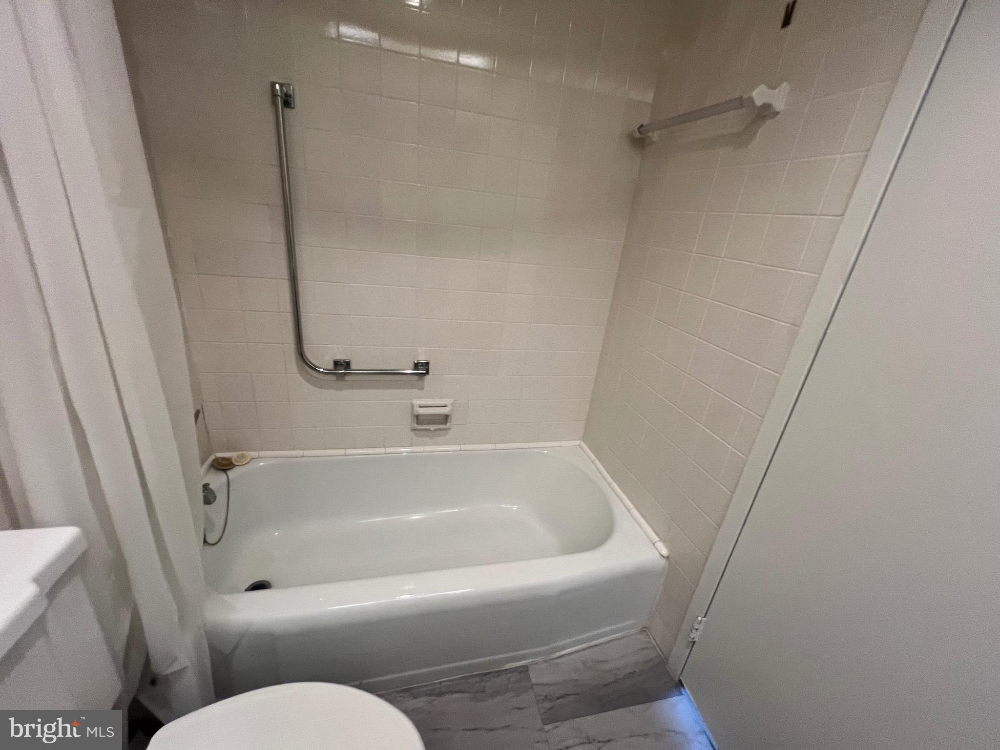 4401 Roland Avenue, Unit 402 Baltimore, MD 21210 - Photo 29 of 43 a white bath tub sitting next to a toilet