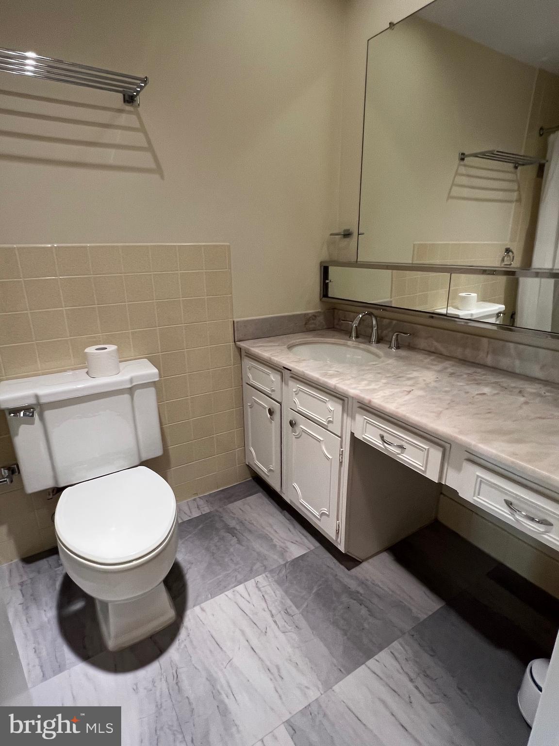 4401 Roland Avenue, Unit 402 Baltimore, MD 21210 - Photo 33 of 43 a bathroom with a granite countertop toilet and a sink