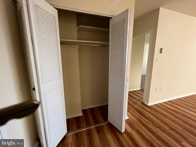a view of walk in closet with wooden floor
