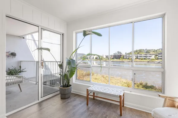 a view of a living room with a floor to ceiling window and wooden floor