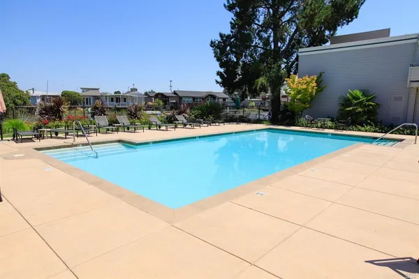 a view of a backyard with chairs and floor to ceiling window