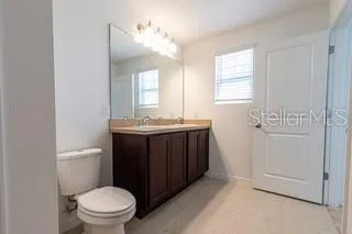 a bathroom with a sink vanity mirror and toilet