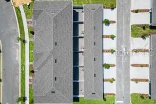 a front view of a house with a garden and lake view