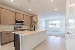 a kitchen with stainless steel appliances granite countertop a sink stove and microwave